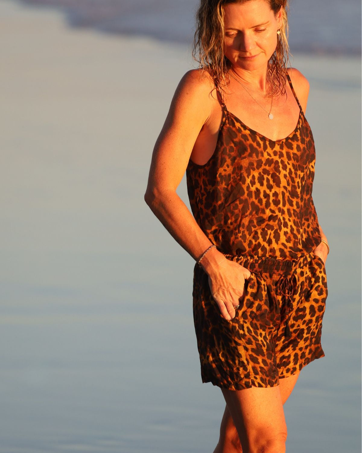 Woman in a leopard print top standing on a beach