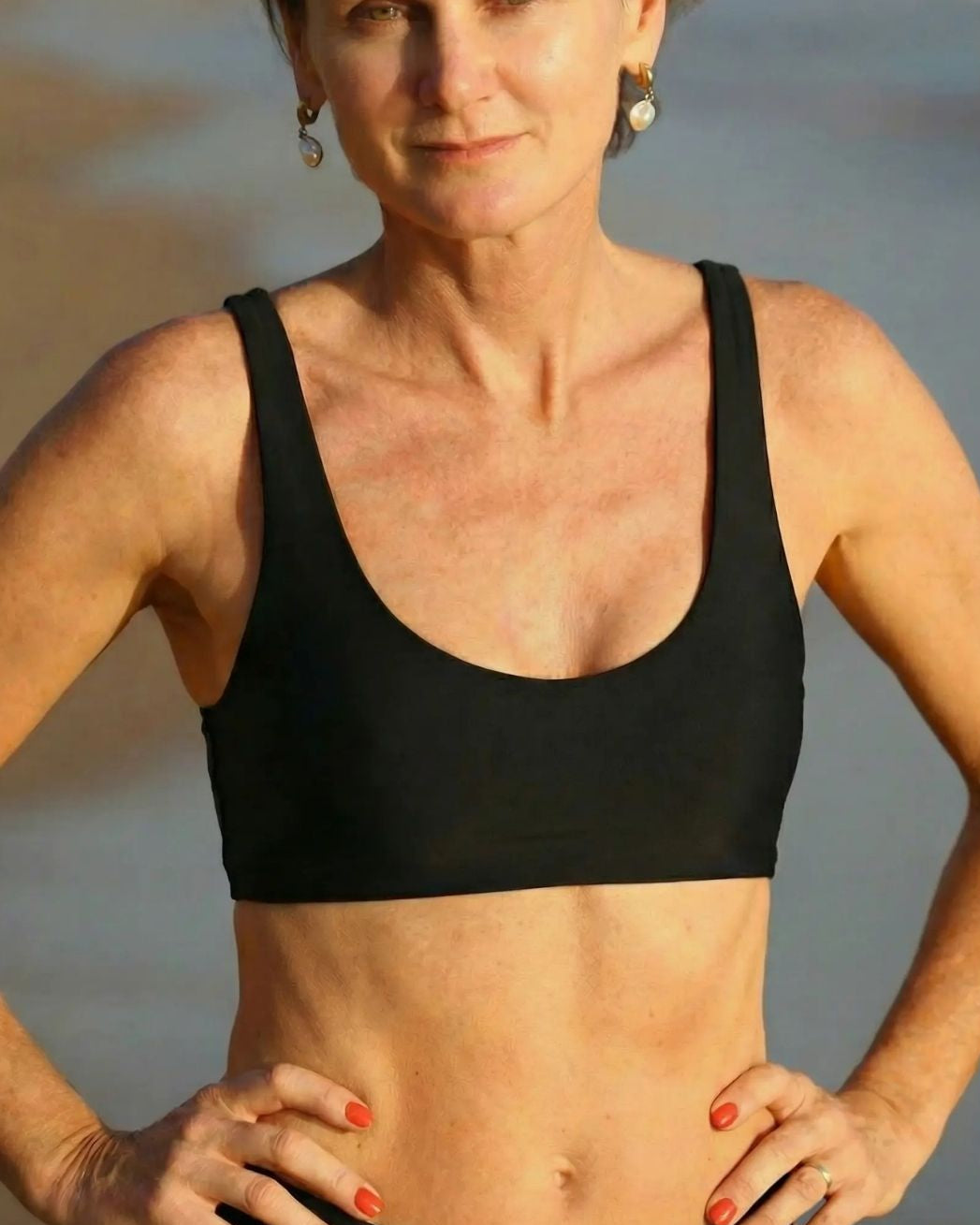 Woman wearing a black sports bra with a blurred background